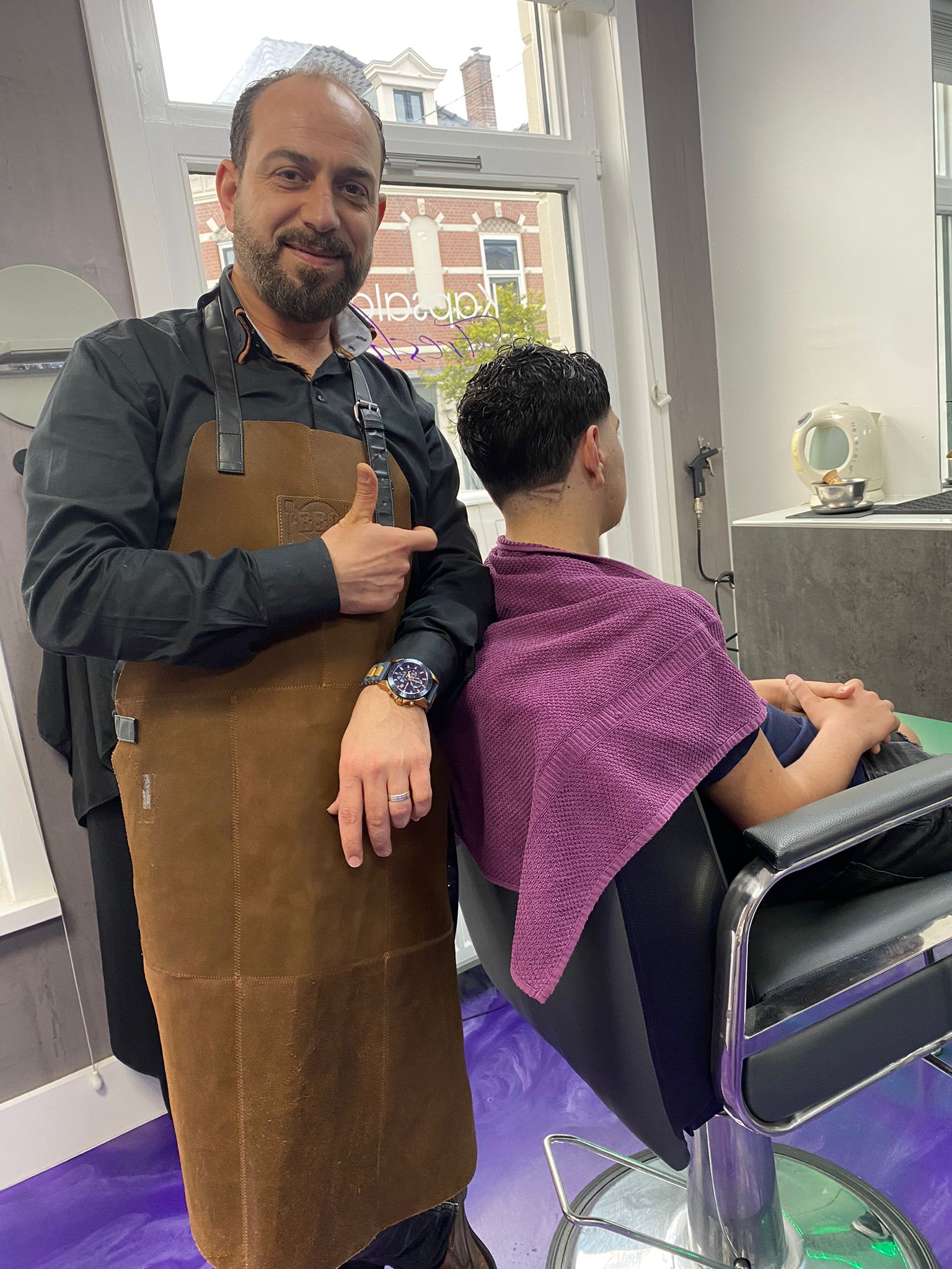Eigenaar Fawaz van Kapsalon Fresh knipt klant thuis in Poortugaal, internationale ervaring met kapsels